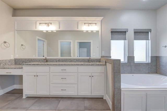 bathroom featuring tile patterned floors, a tub to relax in, and vanity