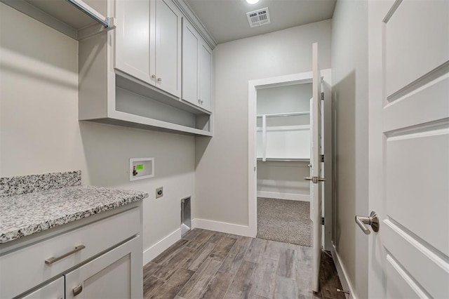 washroom with cabinets, electric dryer hookup, washer hookup, and light hardwood / wood-style floors