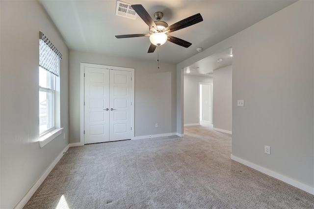 unfurnished bedroom featuring light colored carpet, a closet, and ceiling fan