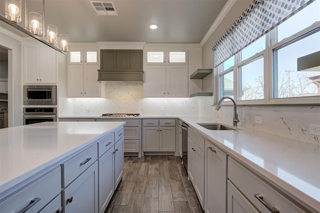 kitchen featuring visible vents, open shelves, a sink, stainless steel appliances, and crown molding