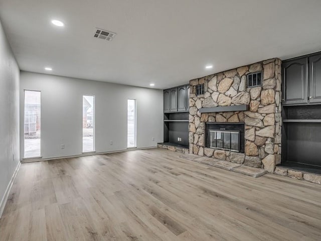 unfurnished living room with light wood-type flooring and a fireplace