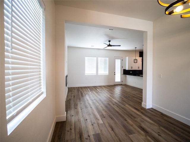 unfurnished living room featuring dark hardwood / wood-style floors and ceiling fan