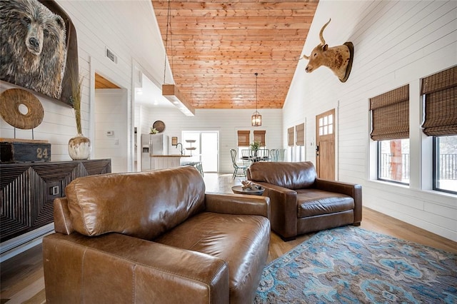 living area with wood finished floors, wood walls, high vaulted ceiling, and wood ceiling