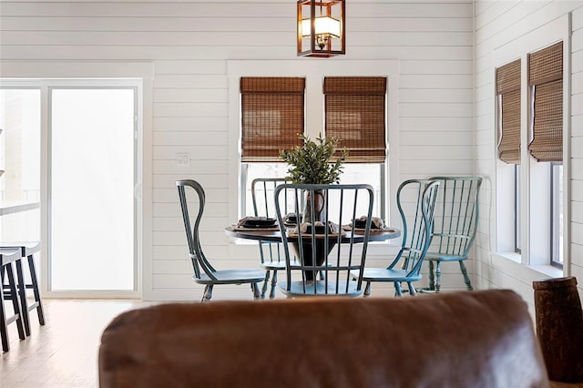 dining area featuring wood walls and wood finished floors