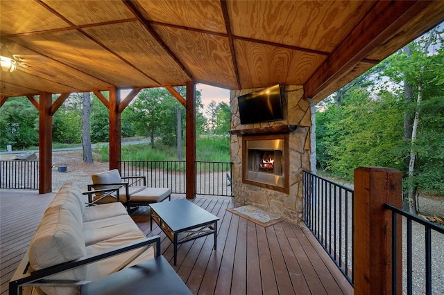 wooden deck with an outdoor living space with a fireplace