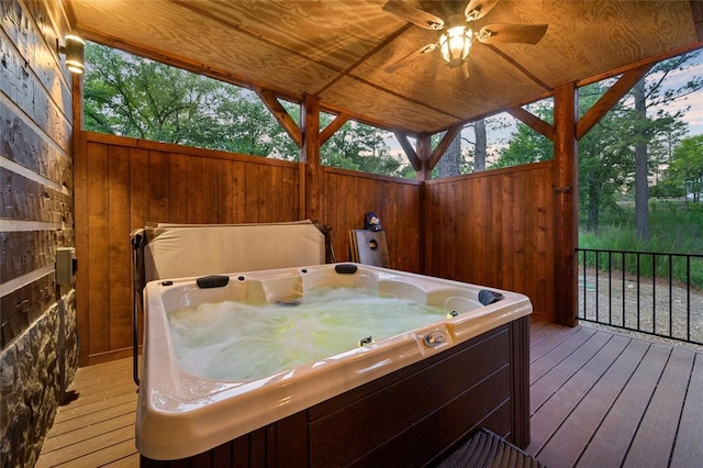 wooden deck featuring ceiling fan and a hot tub