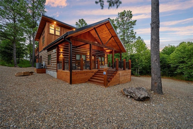 view of property exterior featuring board and batten siding, stairs, and central air condition unit