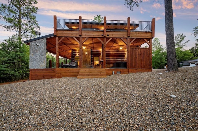 back of property at dusk with a wooden deck
