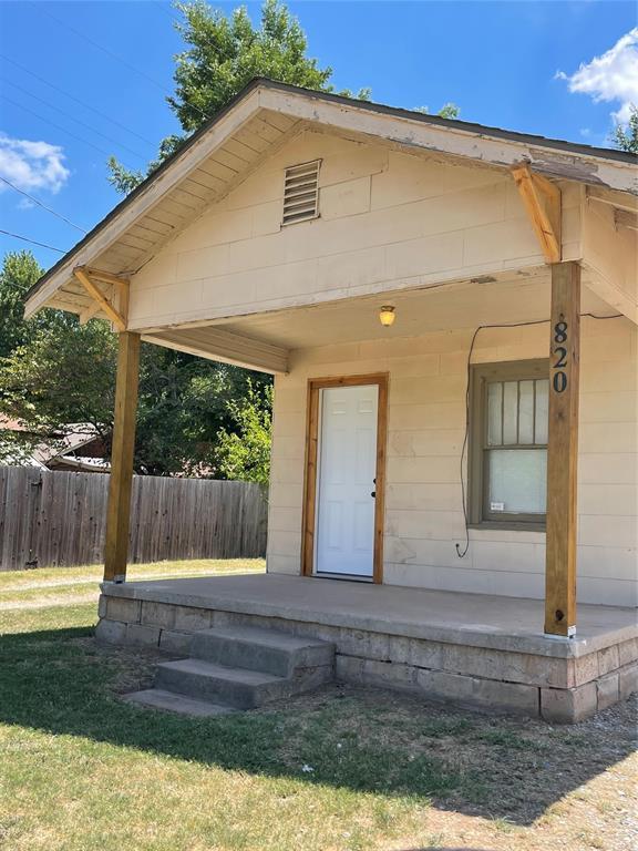 view of exterior entry with a yard