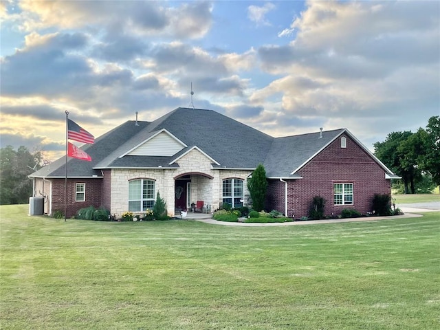 view of front of home with central AC unit and a front yard