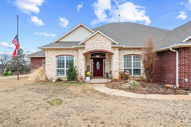 329826 E Hwy 66, Wellston, OK 74881 - french country home featuring a shingled roof, stone siding, and brick siding