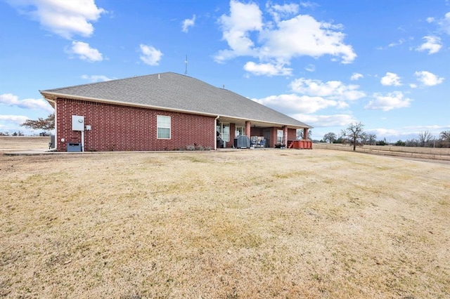 329826 E Hwy 66, Wellston, OK 74881 - back of house featuring brick siding, a shingled roof, and a yard