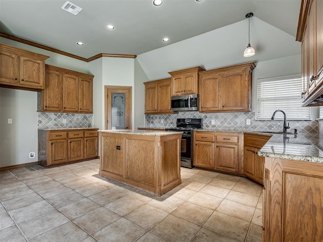 kitchen with black gas range, pendant lighting, vaulted ceiling, a center island, and sink