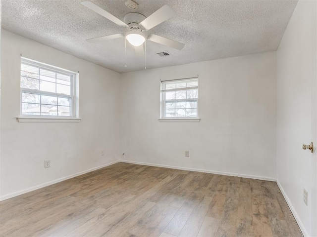 unfurnished room featuring a textured ceiling, ceiling fan, and light hardwood / wood-style flooring