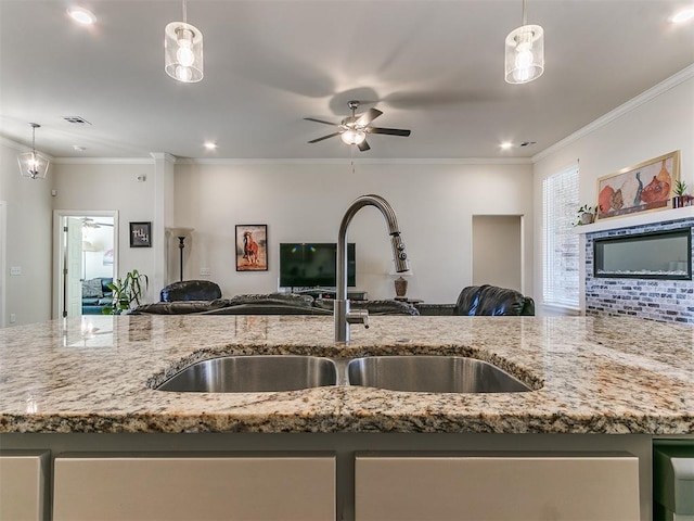 kitchen featuring light stone counters, ceiling fan, and hanging light fixtures