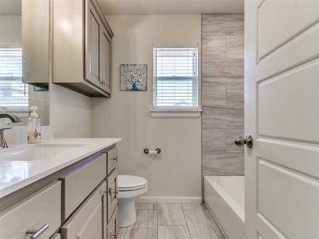 full bathroom with vanity, tiled shower / bath, and toilet