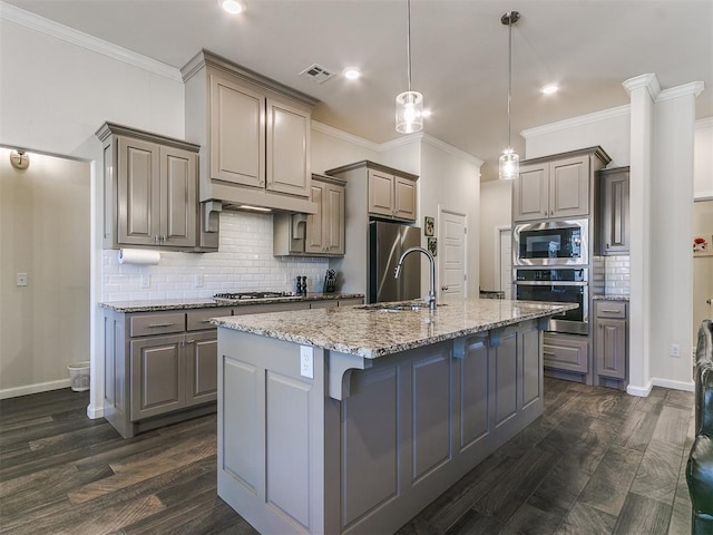3683 King Arthur Ct, Newcastle, OK 73065 - kitchen featuring stainless steel appliances, gray cabinets, tasteful backsplash, a center island with sink, and dark wood finished floors