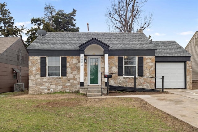 view of front of house featuring a garage, a front lawn, and central air condition unit