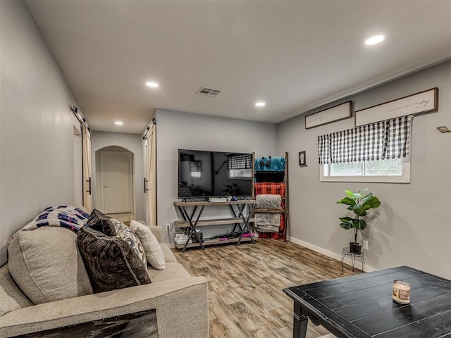 living room featuring hardwood / wood-style flooring and a barn door