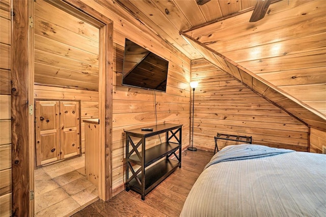 bedroom with wooden ceiling, light hardwood / wood-style flooring, and wood walls