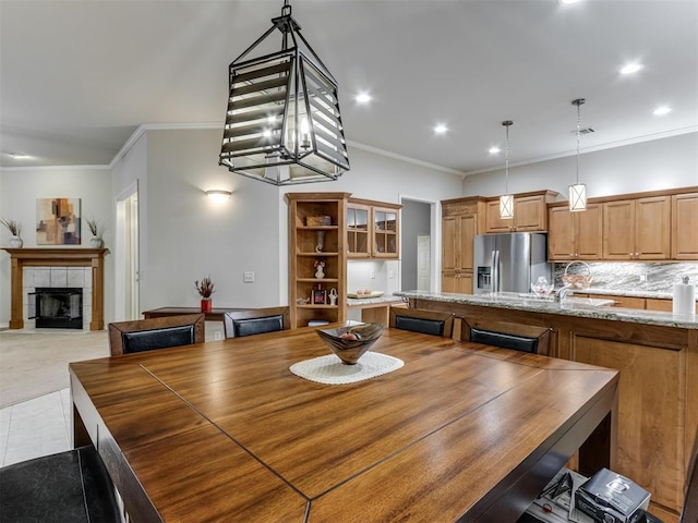 dining space featuring sink, a fireplace, and ornamental molding