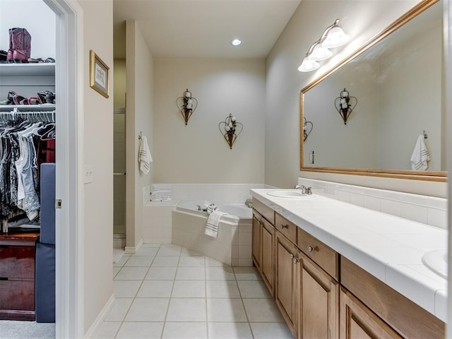 bathroom with vanity, tiled tub, and tile patterned floors