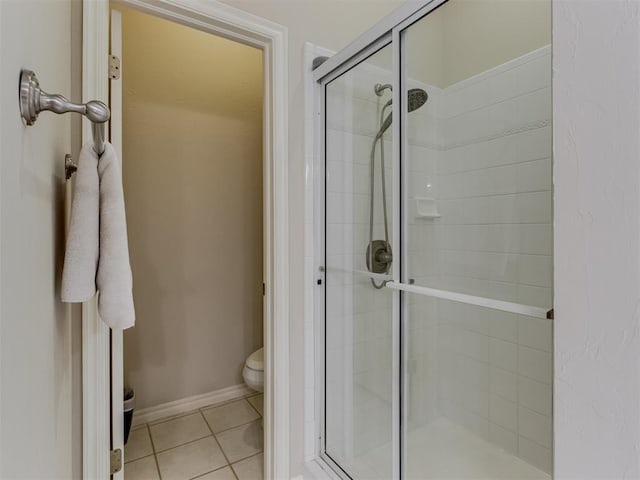 bathroom with toilet, tile patterned floors, and walk in shower