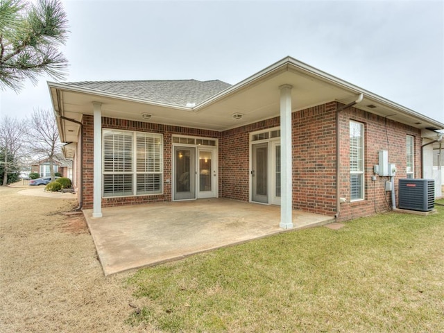 rear view of property featuring a yard, cooling unit, and a patio area