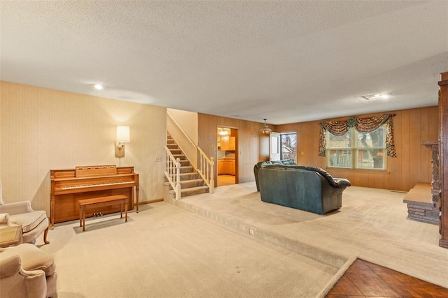 living room featuring carpet, a textured ceiling, and wood walls