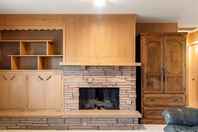 interior details featuring a stone fireplace and wooden walls