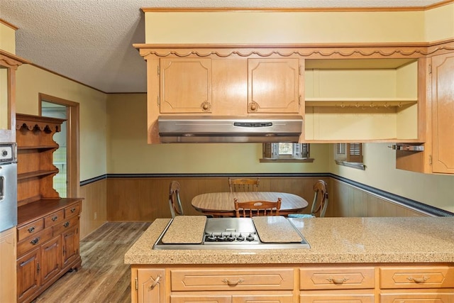 kitchen with hardwood / wood-style flooring, gas cooktop, a textured ceiling, and light brown cabinets