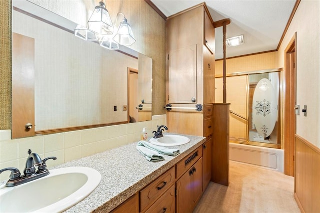 bathroom with bath / shower combo with glass door, ornamental molding, vanity, and backsplash