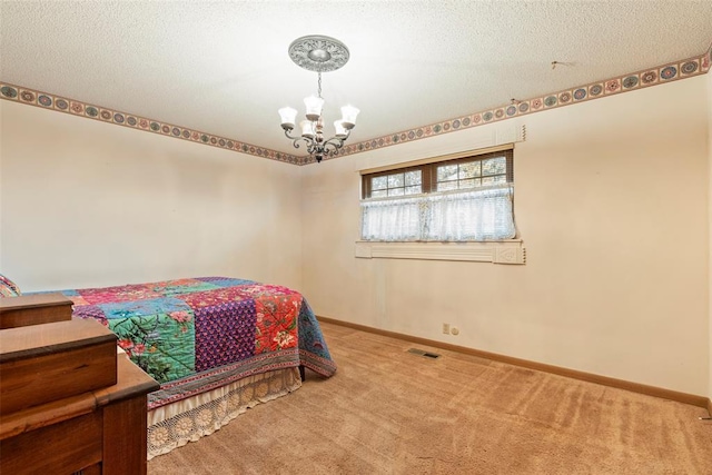 bedroom featuring an inviting chandelier, a textured ceiling, and carpet flooring