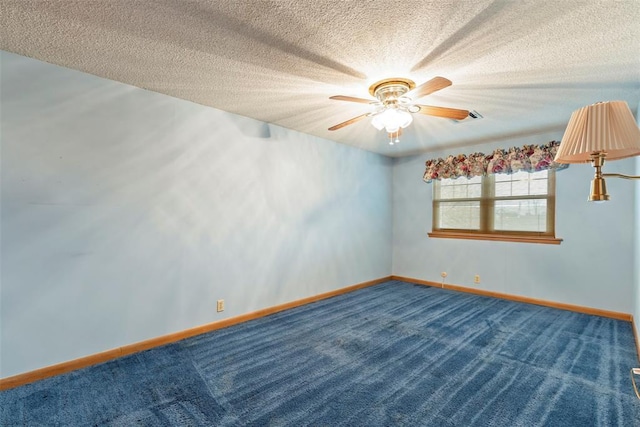 carpeted empty room featuring ceiling fan and a textured ceiling