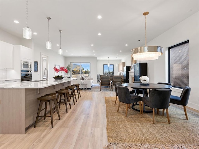 dining space with light wood-type flooring and recessed lighting