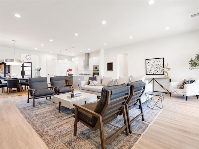 living room with visible vents, light wood-style flooring, and recessed lighting