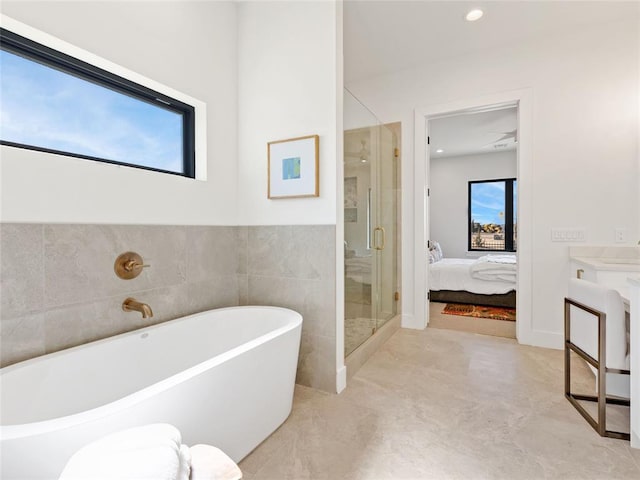 ensuite bathroom featuring recessed lighting, vanity, a freestanding bath, a stall shower, and ensuite bath