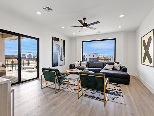 living room featuring light wood finished floors, recessed lighting, visible vents, a ceiling fan, and baseboards