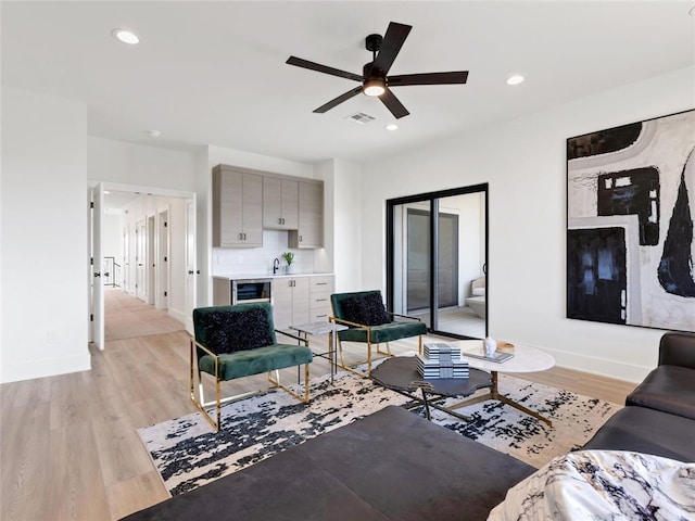 living area with light wood-style flooring, visible vents, and recessed lighting