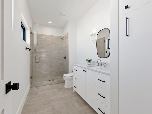 bathroom featuring toilet, visible vents, vanity, baseboards, and a shower stall