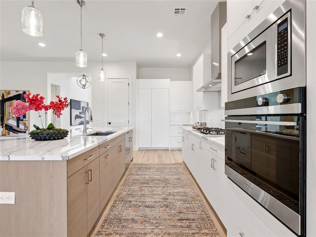810 NW 72nd St, Oklahoma City, OK 73116 - kitchen featuring a sink, modern cabinets, stainless steel appliances, wall chimney range hood, and visible vents