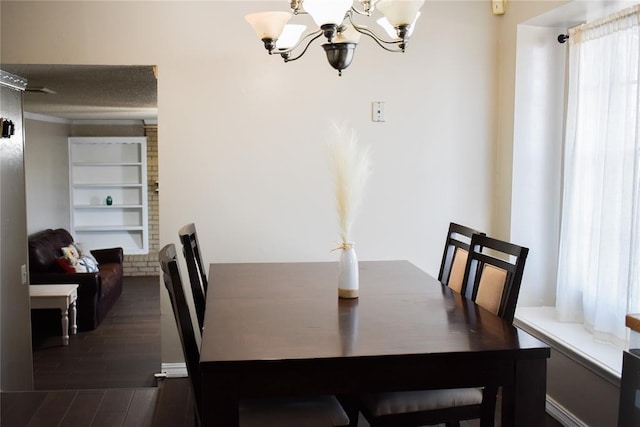 dining room featuring dark hardwood / wood-style flooring, an inviting chandelier, and built in shelves