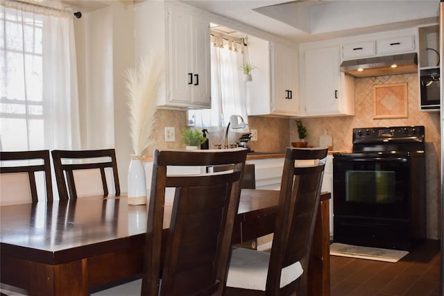 kitchen featuring white cabinetry, black range with electric stovetop, and decorative backsplash