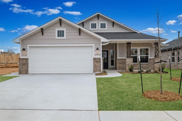 craftsman house with covered porch, a front lawn, and a garage