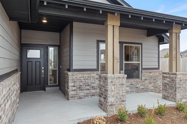 entrance to property with brick siding and covered porch