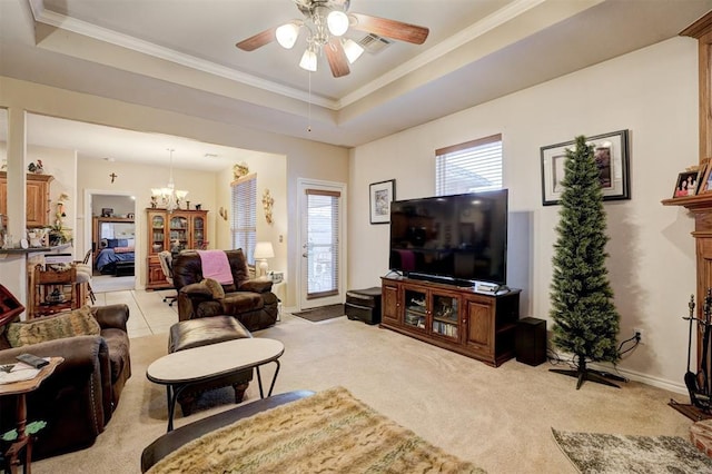 living room with ornamental molding, ceiling fan with notable chandelier, light colored carpet, and a tray ceiling