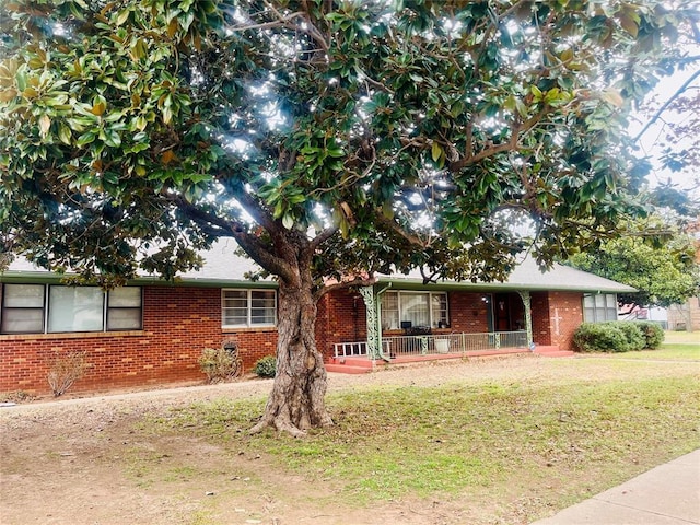 ranch-style home featuring a front lawn and covered porch