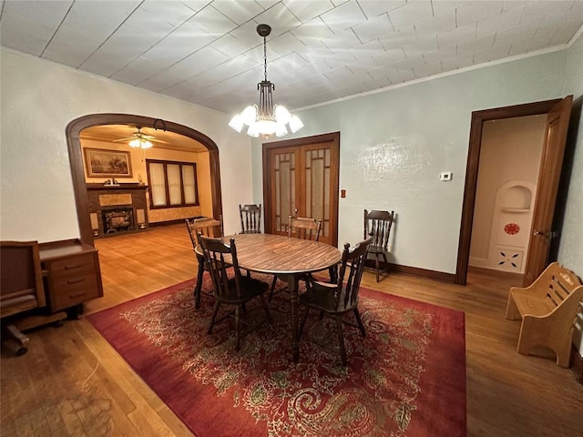 dining space with hardwood / wood-style flooring, ornamental molding, and an inviting chandelier