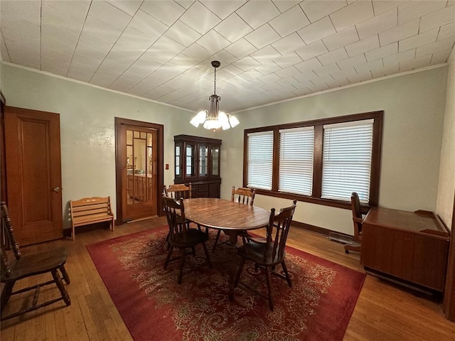 dining room featuring dark hardwood / wood-style flooring, crown molding, and an inviting chandelier