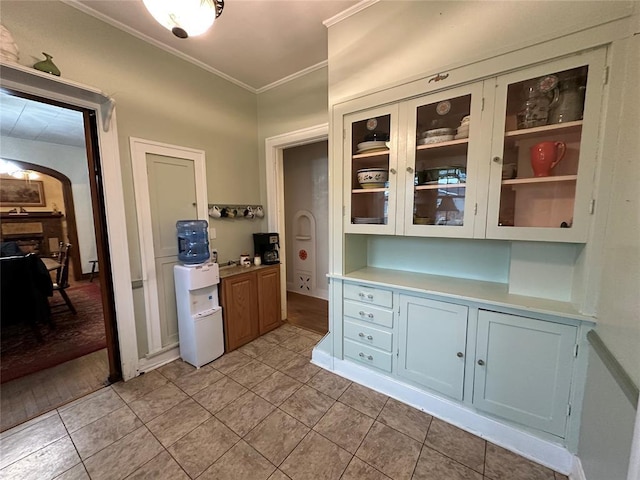 kitchen featuring white cabinetry, light tile patterned floors, and crown molding